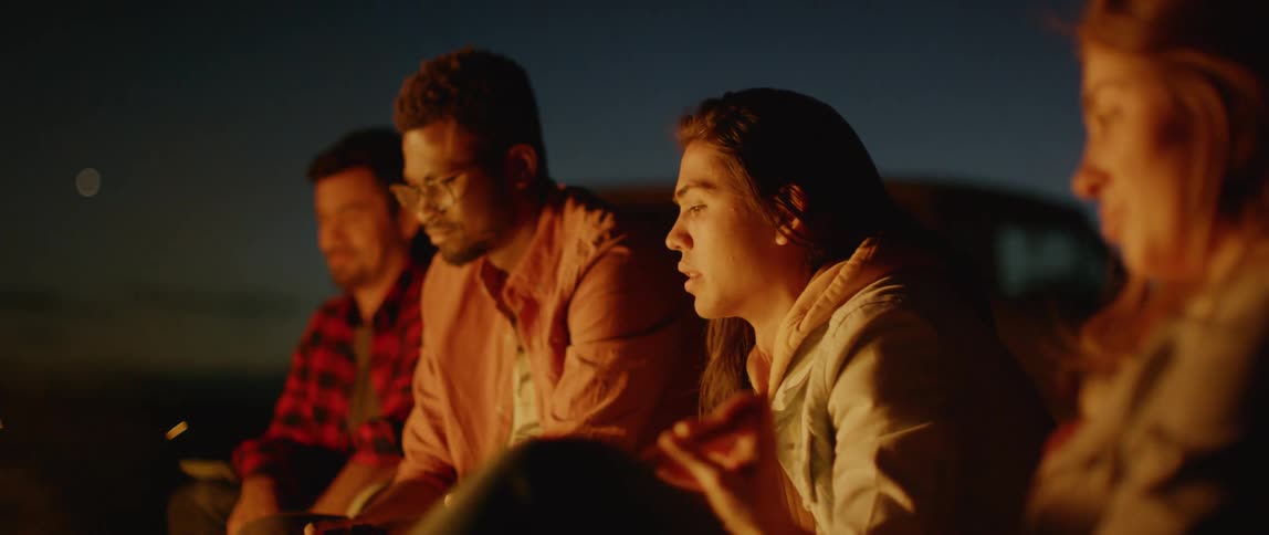 A group of people sit around a campfire