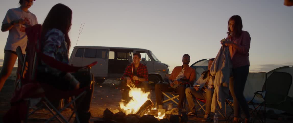 A group of people gather around a campfire