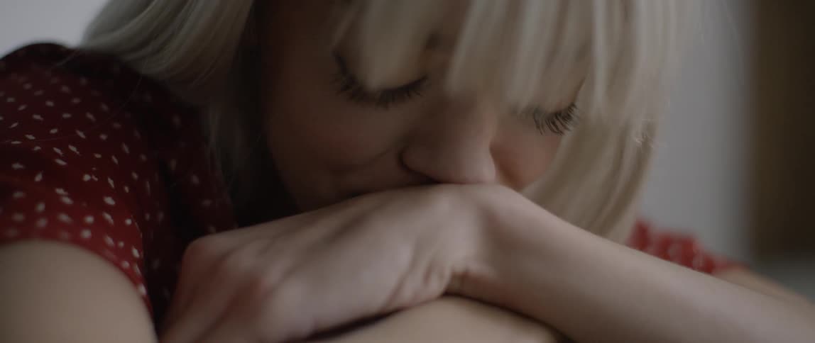 A woman is leaning on her arms crying
