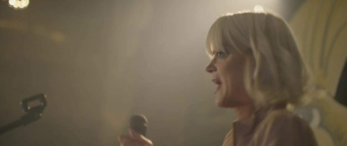 A woman is singing and dancing on the stage