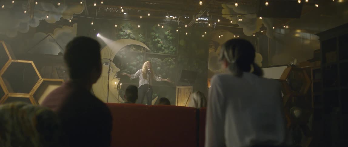 A woman performs karaoke at a karaoke bar