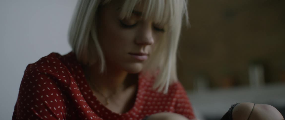 A sad looking woman lies back in a bed
