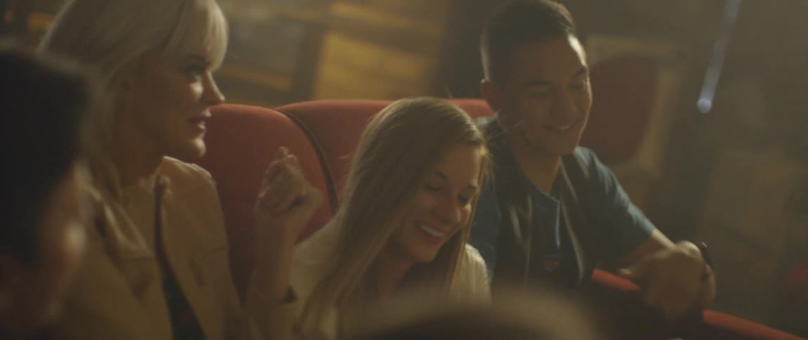 A group of people dance on a couch at a karaoke bar