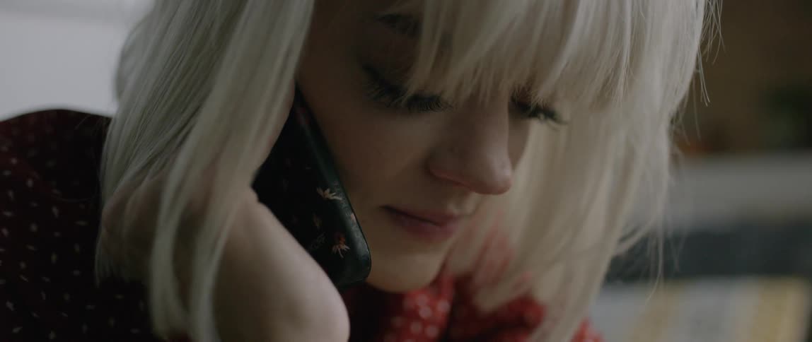 A blond haired woman talks on the phone