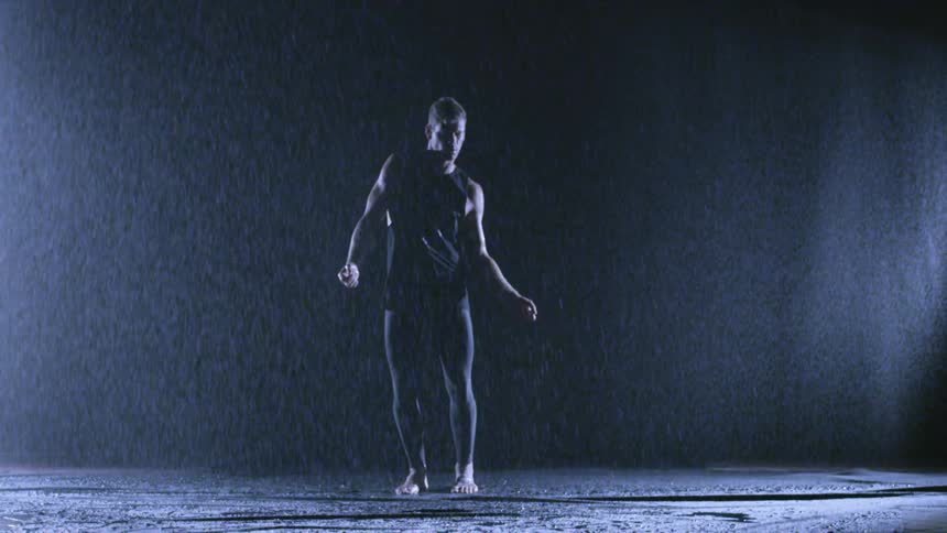 Man dancing out in the rain at night