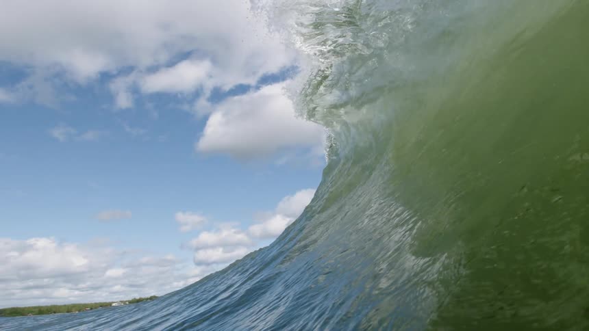 Green tinged water forms a curving wave