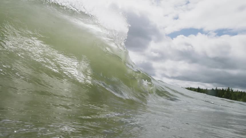 Wave forming and rolling over the waters on a cloudy day