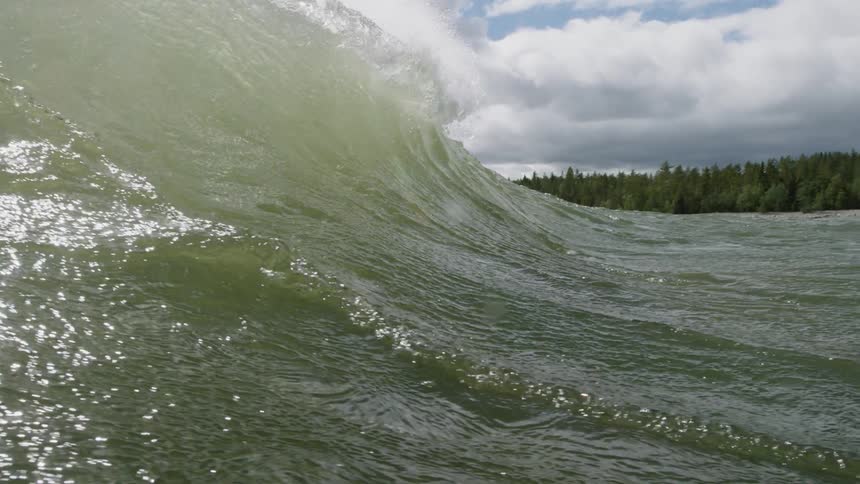 The large wave is tumbling over towards the shore