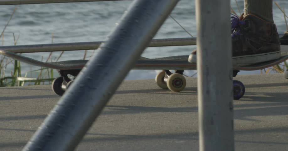Close up of a skateboard on a sidewalk next to water