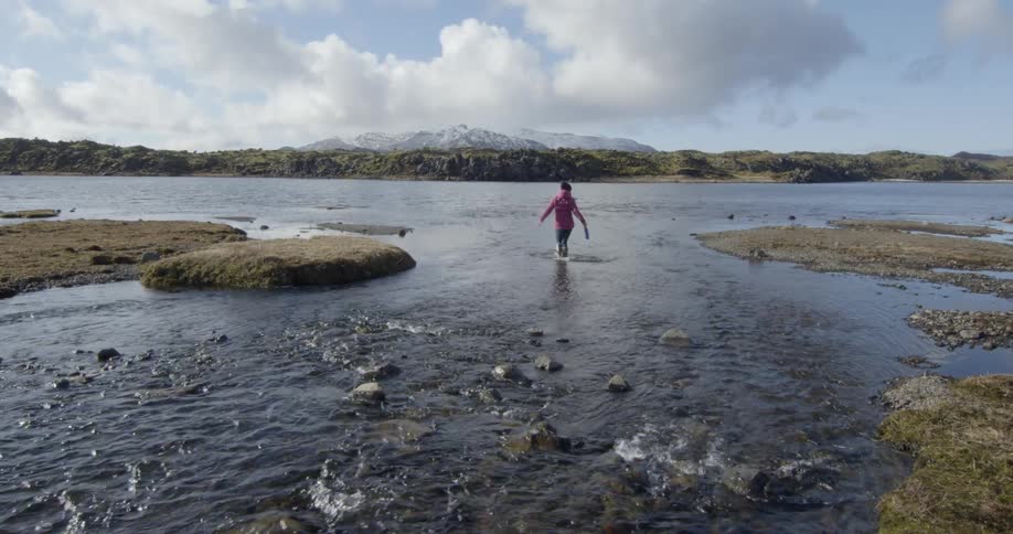 Woman splashing and dancing in a shallow lake of water