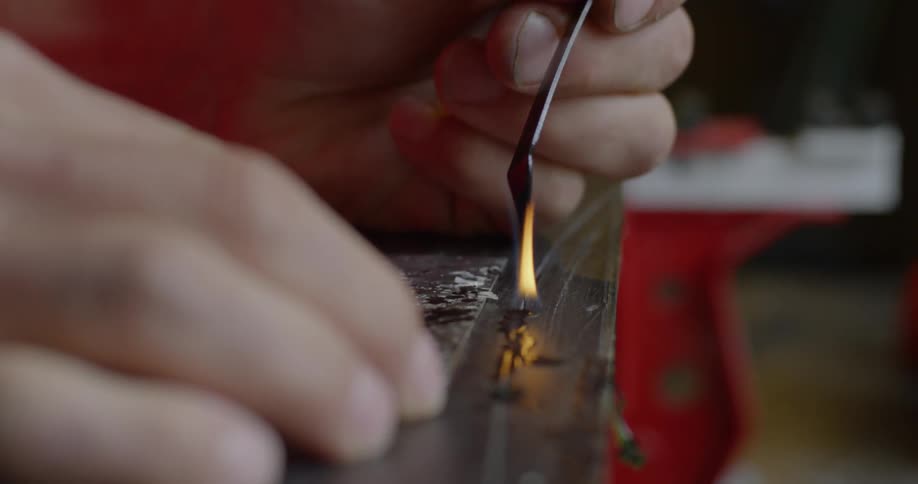 A man is melting wax onto a board