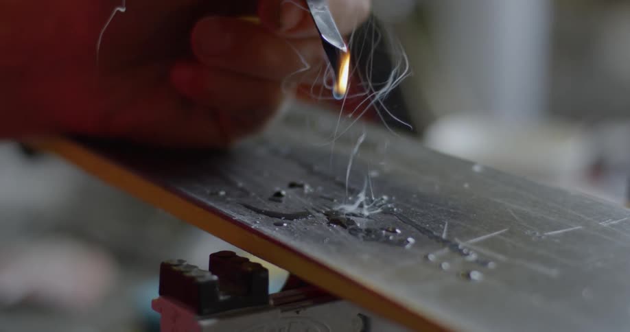 Person holds a piece of metal dripping and on fire