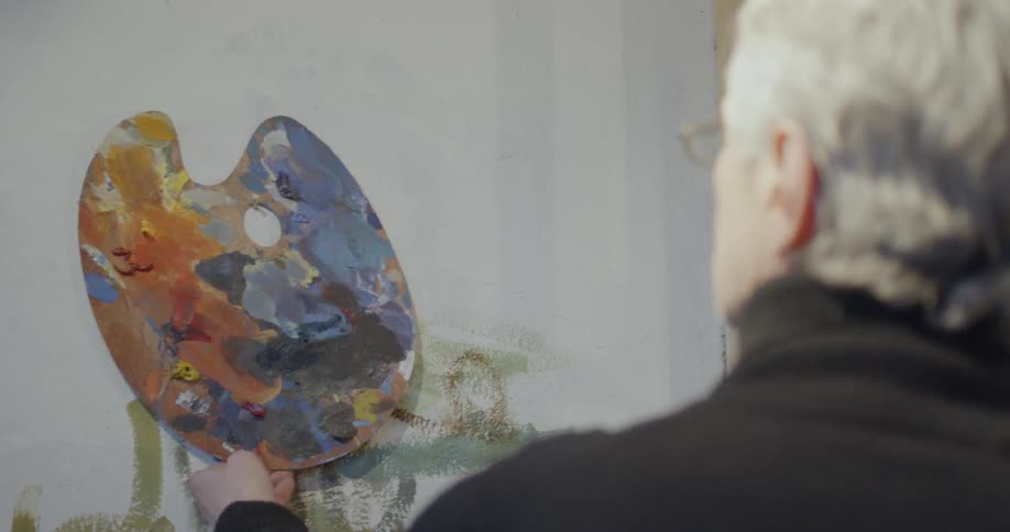 An artist grabs his palette off the wall