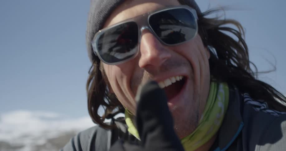Smiling man wearing sunglasses nods his head and gives a thumbs up