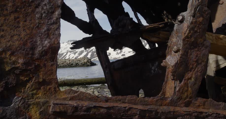 A rested metal ship sits in a snowy harbor