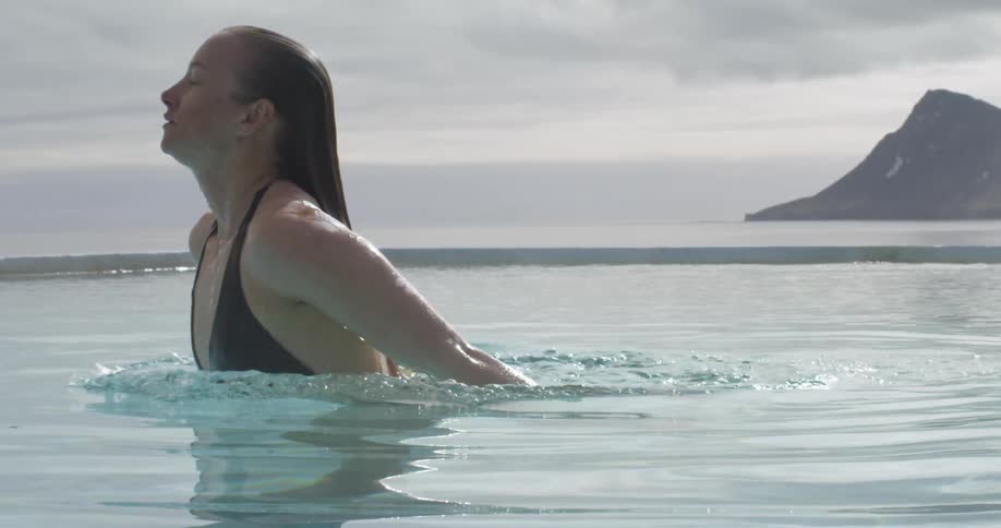 Woman rises up from water on a cloudy day