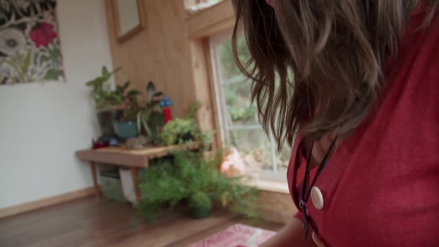 A woman in red taps a musical instrument