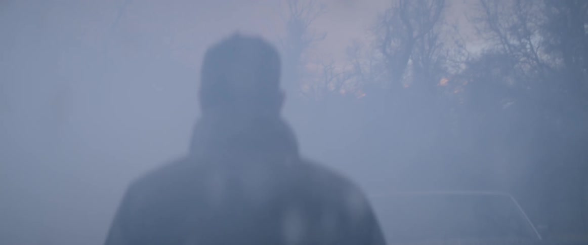 A man walks toward a forest on a snowy day
