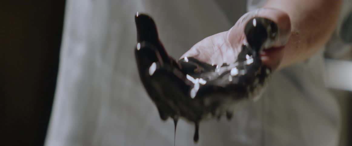 Paint is dripping off a woman's hand
