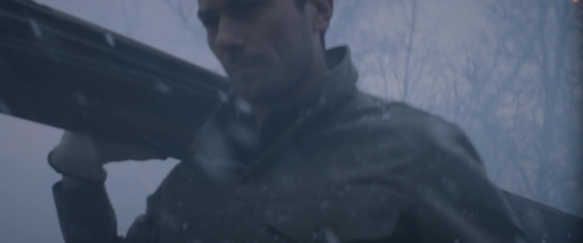 A man is carrying boards as he walks outside while it snows