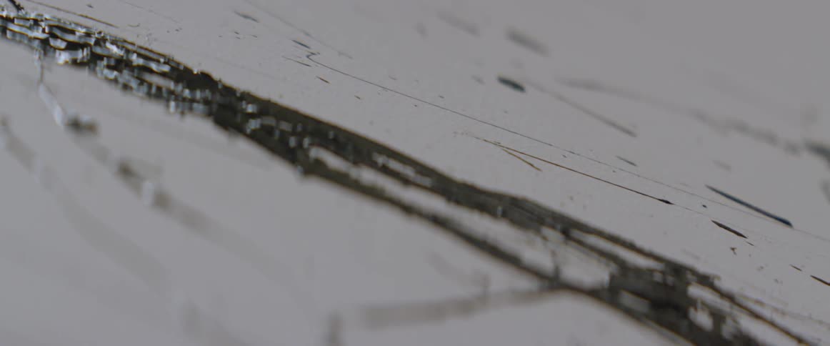 Black paint is splattered on a white canvas