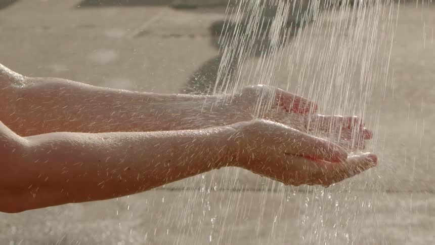 A person washes their hands outside