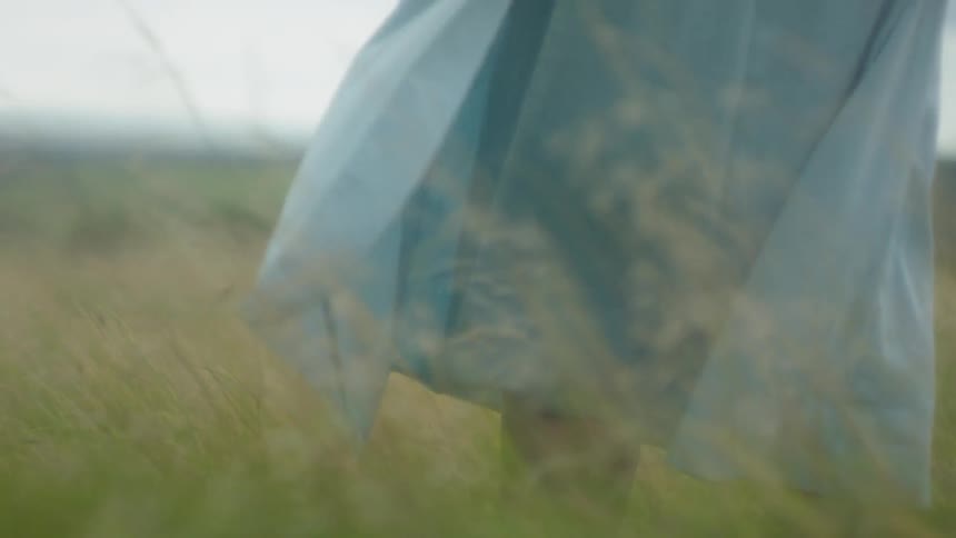 Person stands still as their skirt waves in the wind