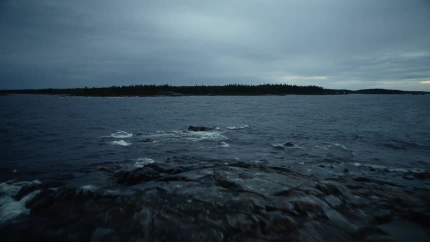 Waves crash into rocks on a cloudy day