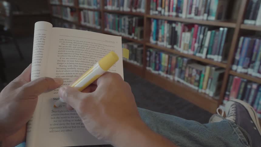 A person highlights a sentence in a book