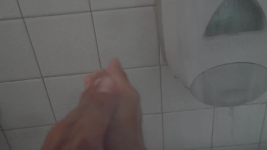 A person pumps soap into their hands and lathers it