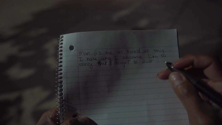 Someone is writing a note on a piece of paper and then rips it out