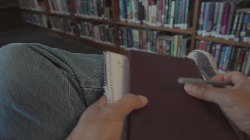 A student stands up after writing in a library