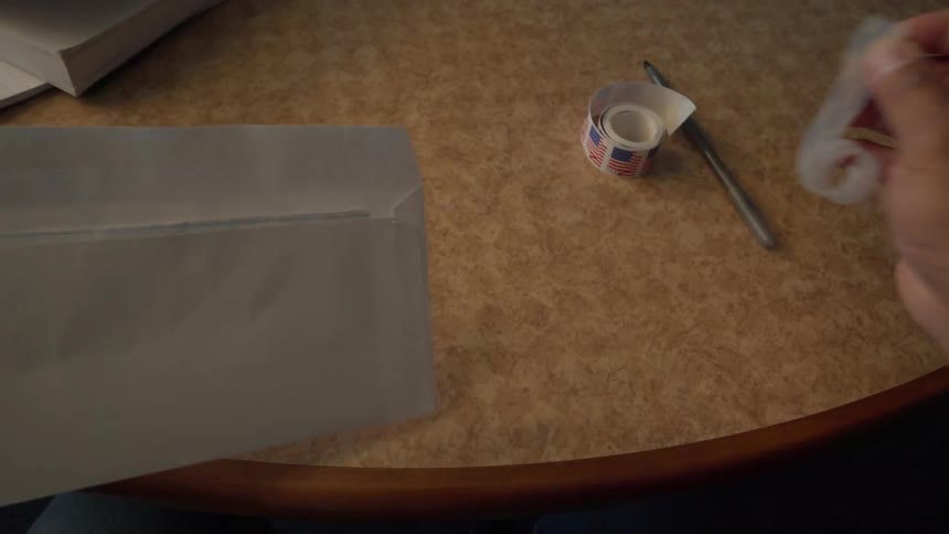 Man puts a letter in an envelope