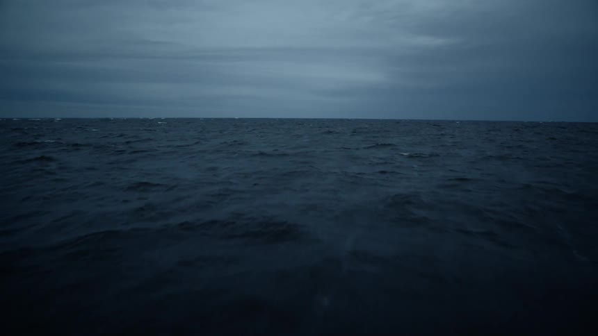 Ocean waves flow under cloudy skies