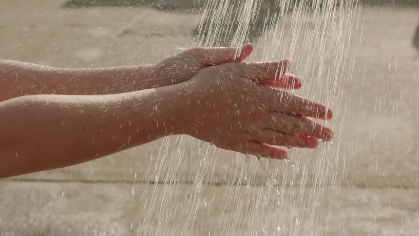 A person washing their hands outside