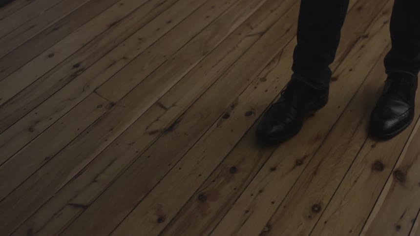 A man walks on a wood floor