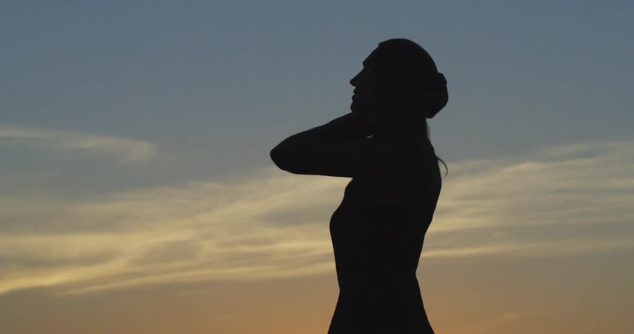 A silhouette of a person against a sunset