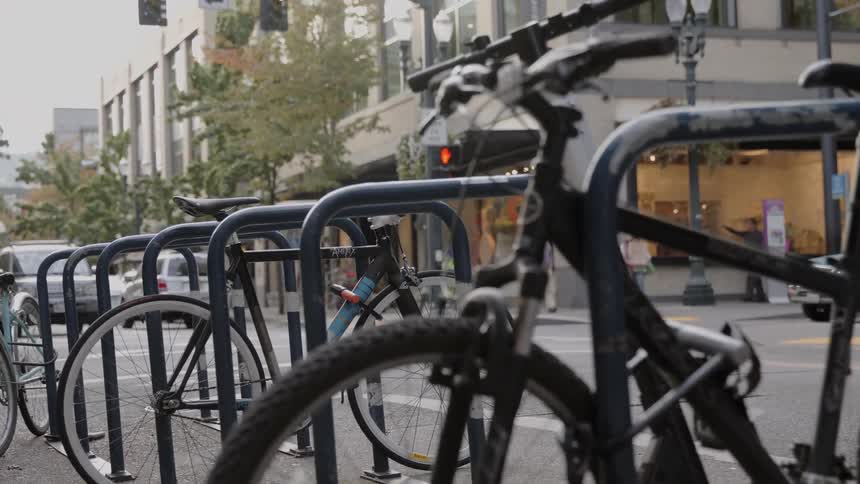 Bicycles are locked to a bike rack in a city