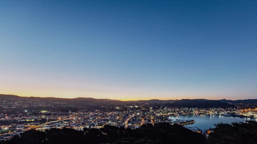 The lights come on in a city as daytime fades to night