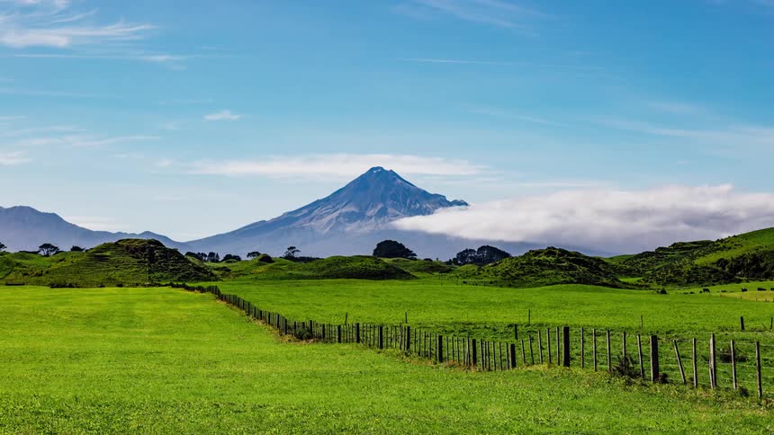 Clouds pass over a lush green farmland field