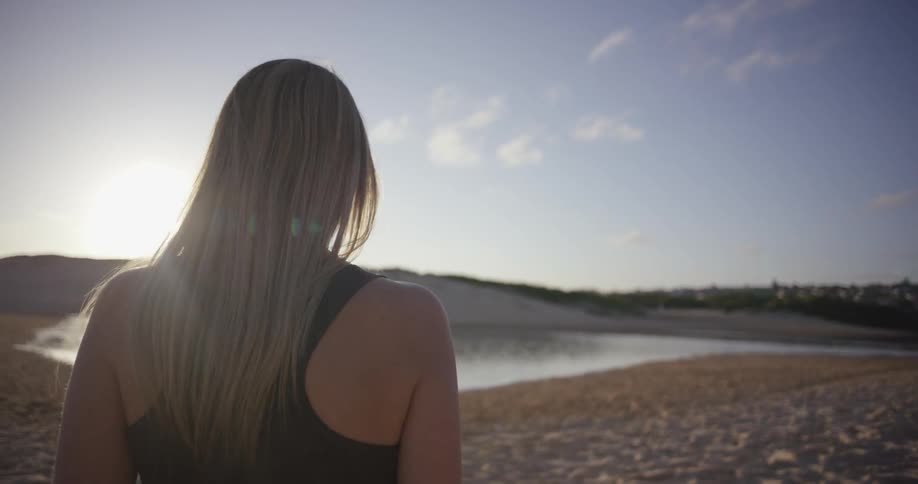 A woman walks on a sandy beach