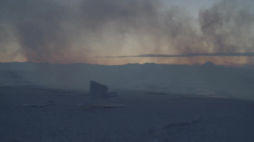 Paper moves with the wind on salt flats at sunset
