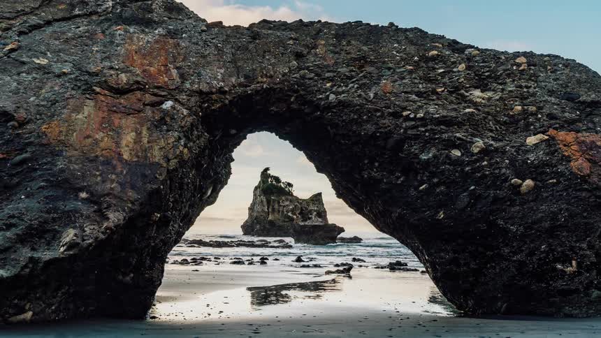 A rock archway on a beach