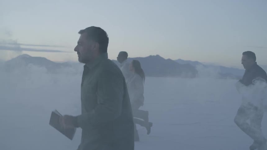 People run across salt flats at sunset