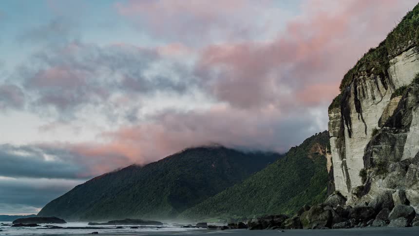 Clouds roll over a mountain near the beach