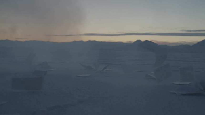 Paper moves with the wind on salt flats at sunset