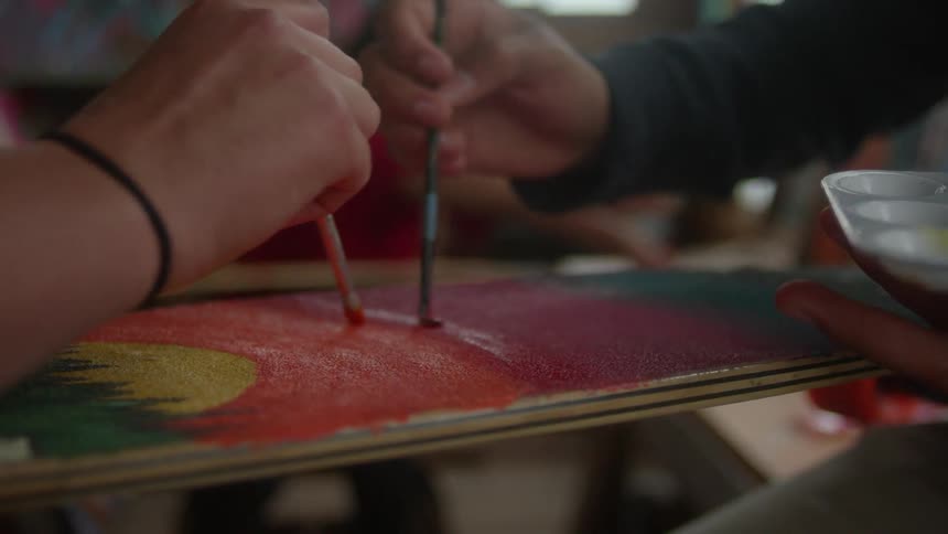 Artists paint on a canvas together