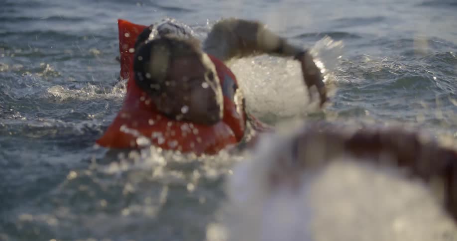 People swim while wearing life vests