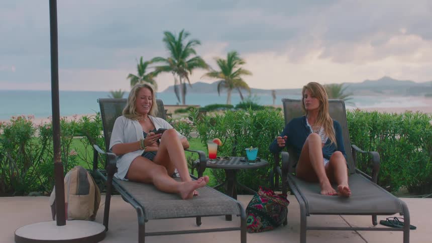 Two women talking on sun loungers