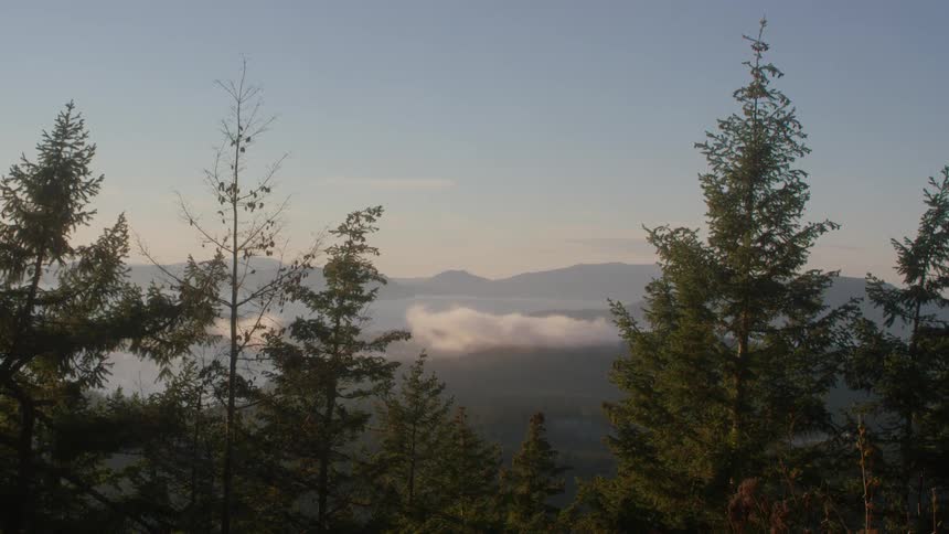 Clouds hover over a mountain valley